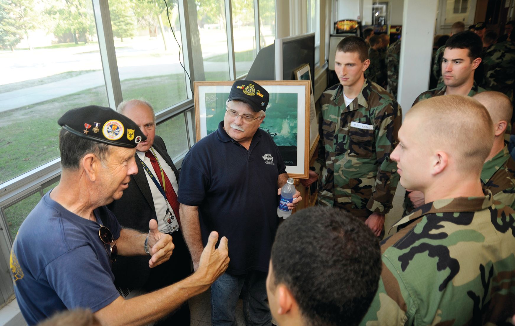 David Larsen, left, a recipient of the Navy Cross for actions in Vietnam, and Joe Rosner, center, both with the Mobile Riverine Force in Vietnam, speak with U.S. Sailors attending the Naval Special Warfare Preparatory School at Naval Station Great Lakes, Illinois, September 2, 2011. 
