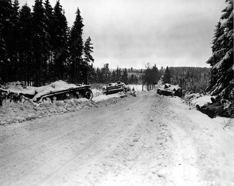 Destroyed and abandoned, these German armored vehicles offer silent testimony to the desperation of the fighting near St. Vith. Before retiring, the American defenders of the town severely hampered German efforts to exploit their Ardennes breakthrough.