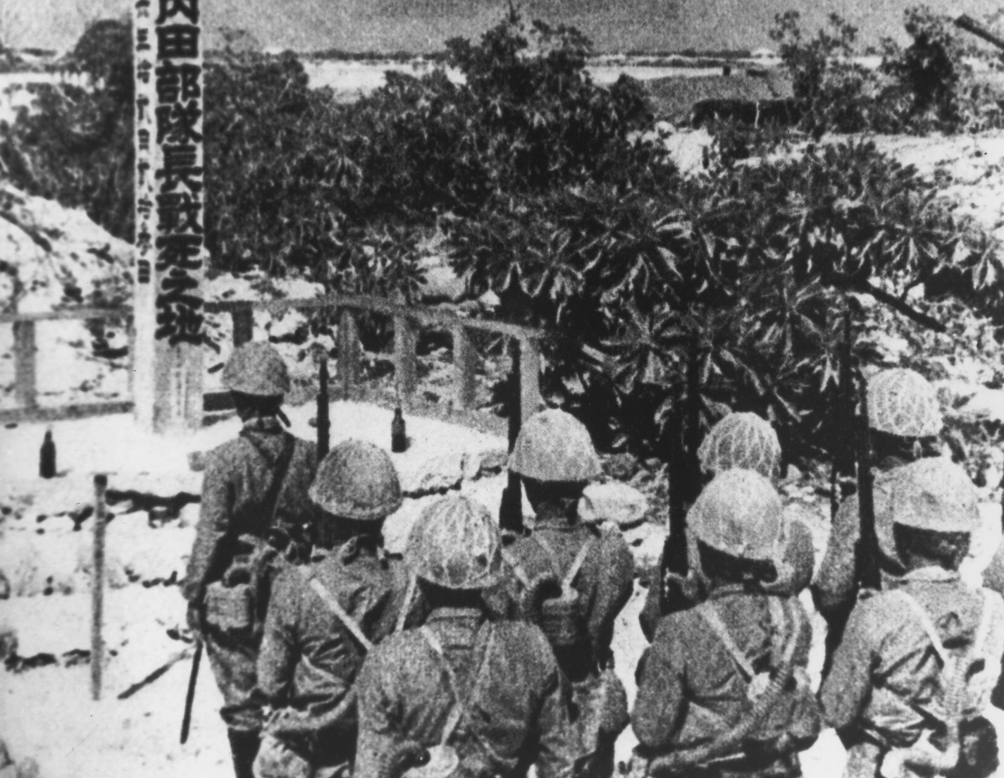 Japanese troops pay their last respects to a fallen comrade killed in action on Wake Island. In retribution for their fallen colleagues the Japanese would behead 5 American POWs.