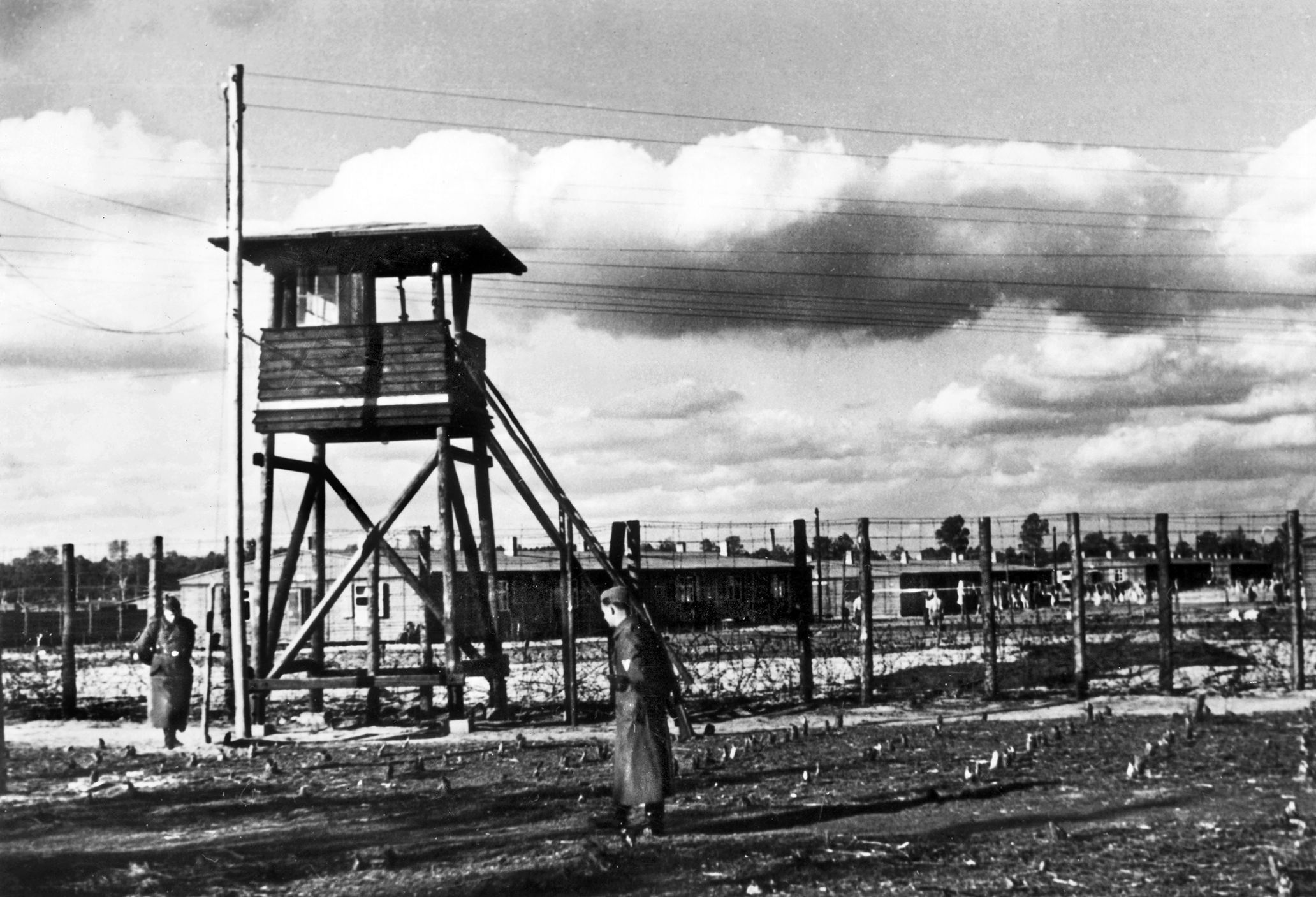 German guards patrol the wire fence around Stalag Luft III at Sagan, Poland—the POW camp for aviators made famous by the 1963 movie, The Great Escape. Ben Ernst helped create the camp's library.