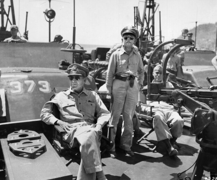 General Douglas MacArthur pauses after fulfilling his promise to return to the Philippines. MacArthur is seen aboard PT-373 at a wrecked dock on the island of Corregidor in Manila Bay. He is accompanied by Brigadier General Carlos P. Romulo, commander of the Philippine Forces of Liberation.