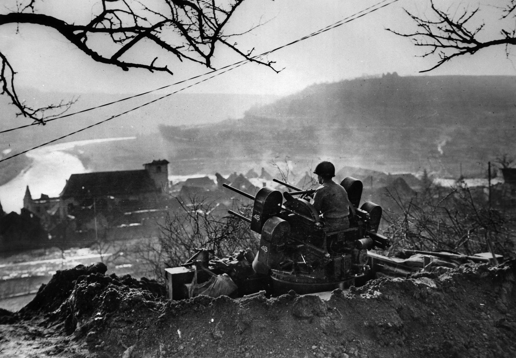 Manning an antiaircraft gun at Wallendorf, Luxembourg, in February 1945, soldiers of the 80th Division look over the Our River. This photo was taken after the reduction of the German advance during the Battle of the Bulge. 