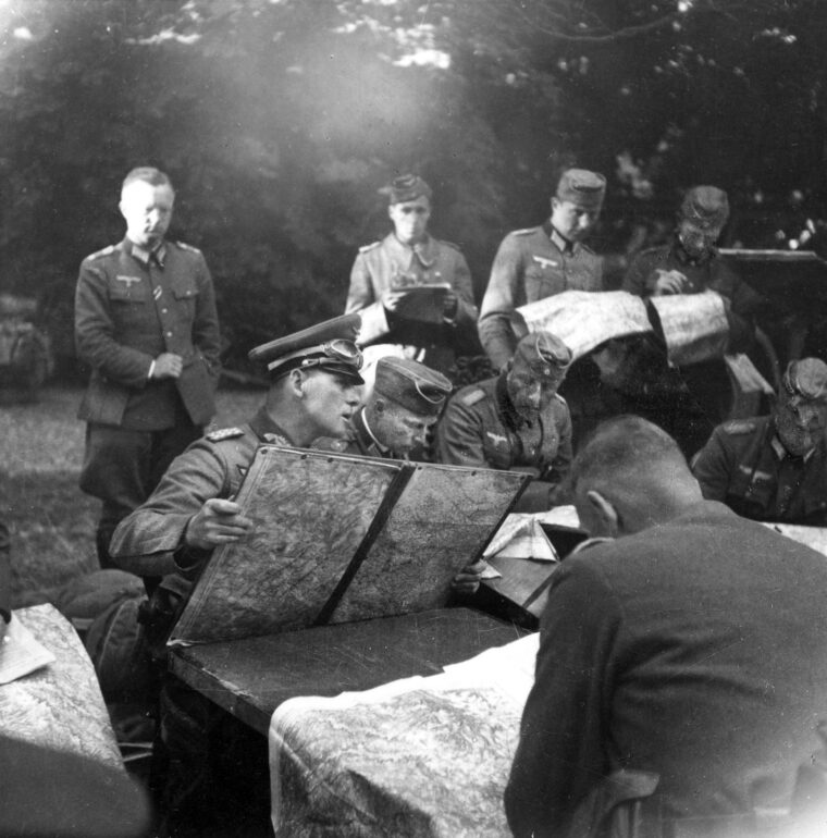 Generalmajor Erwin Rommel, seated center holding map, discusses the next attack with members of his staff during the advance into France in the spring of 1940. Rommel was appointed as a Commander of the 7th Panzer Division in February 1940, replacing Generalleutnant Georg Stumme. 