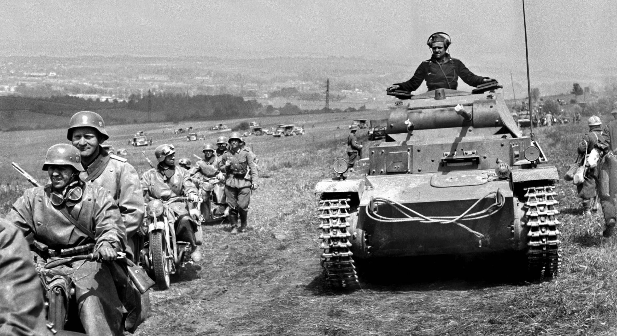 Light tanks (PzKpfw II Ausf. C), motorcycles and cars of a motorized column of the German 10th Panzer Division on the march near Sedan, France, in May 1940. Captured French soldiers are visible on the right. 