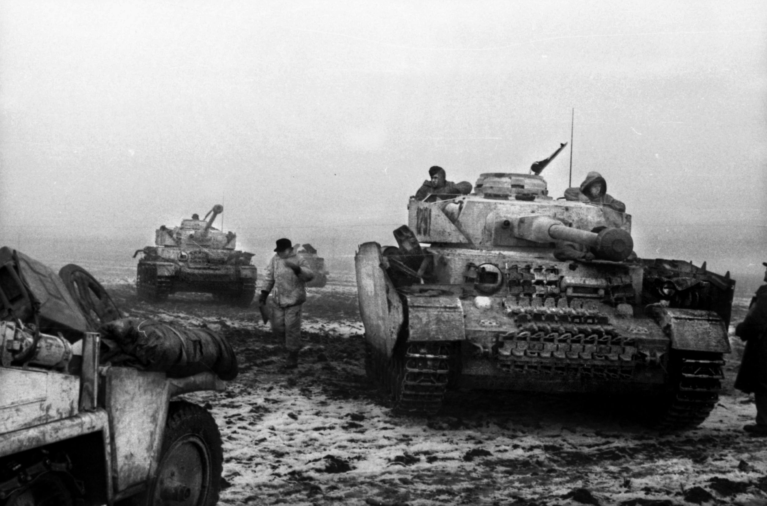 In December, 1943, German PzKpfw. IV tanks followed by panzergrenadiers make their way slowly across a bleak Ukranian landscape that might be knee-deep mud one day and ice the next. By the third week of January, the Germans would be completely surrounded by the Red Army. The lead tank has improvised armor to protect its tracks.