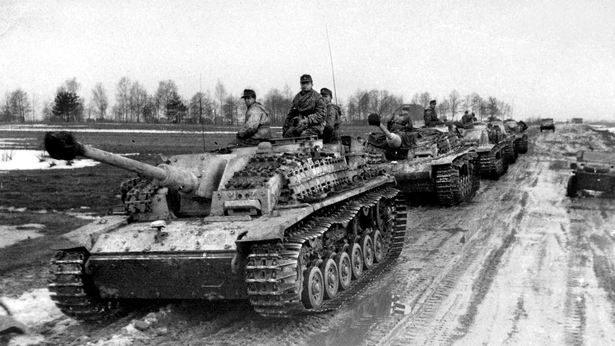 StuG 40 Ausf G tank destroyers move over the muddy melting roads in Ukraine in the winter of 1944. During the encirclement, Luftwaffe Ju-52s dropped petrol barrels into the mud, often 200-300 yards away. Steel wires were attached to winch them in. With ammunition and fuel being prioritized, the Panzer crews and grenadiers received little food.
