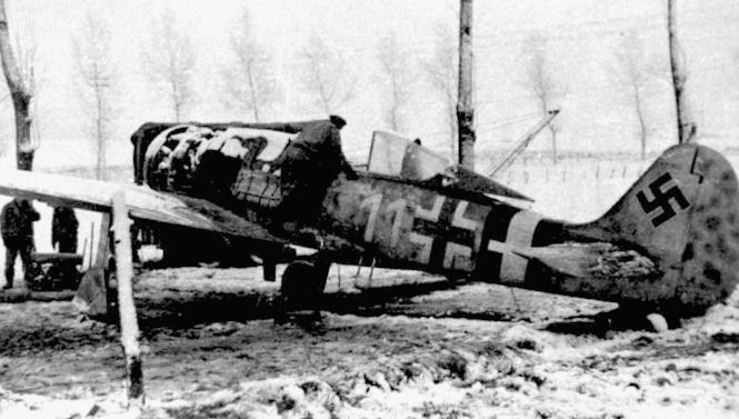 An FW-190 A8 sits on an airfield at St. Trond, Belgium, after making an emergency landing due to Allied flak damage sustained during Operation Bodenplatte.
