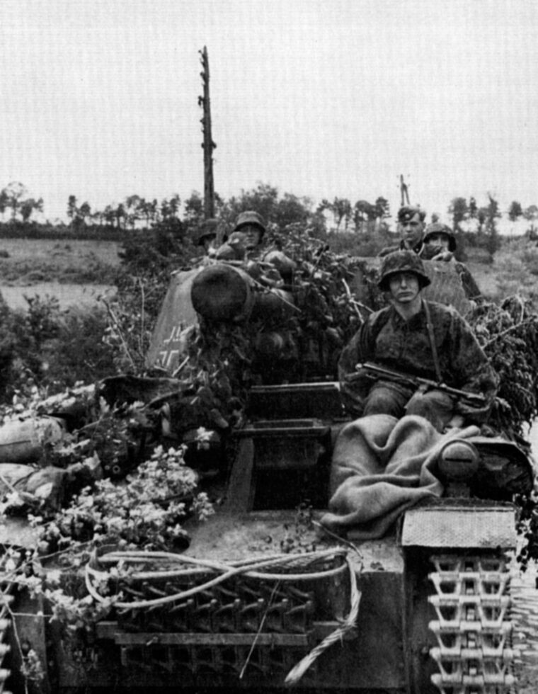 Riding atop a camouflaged self-propelled gun, members of the 12th SS Panzer Division head toward the beaches on June 6, 1944.