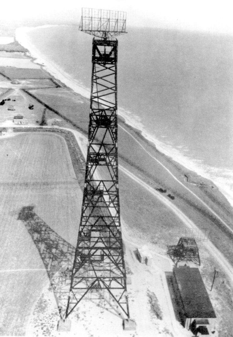 A radar mast stands sentry on the English coast. Bomb blasts had little effect on such towers. 