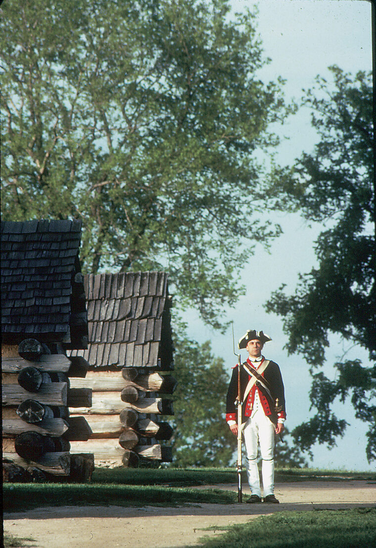 A soldier stands guard near recreated soldiers’ huts at Valley Forge National Park, which lies not far outside the city.