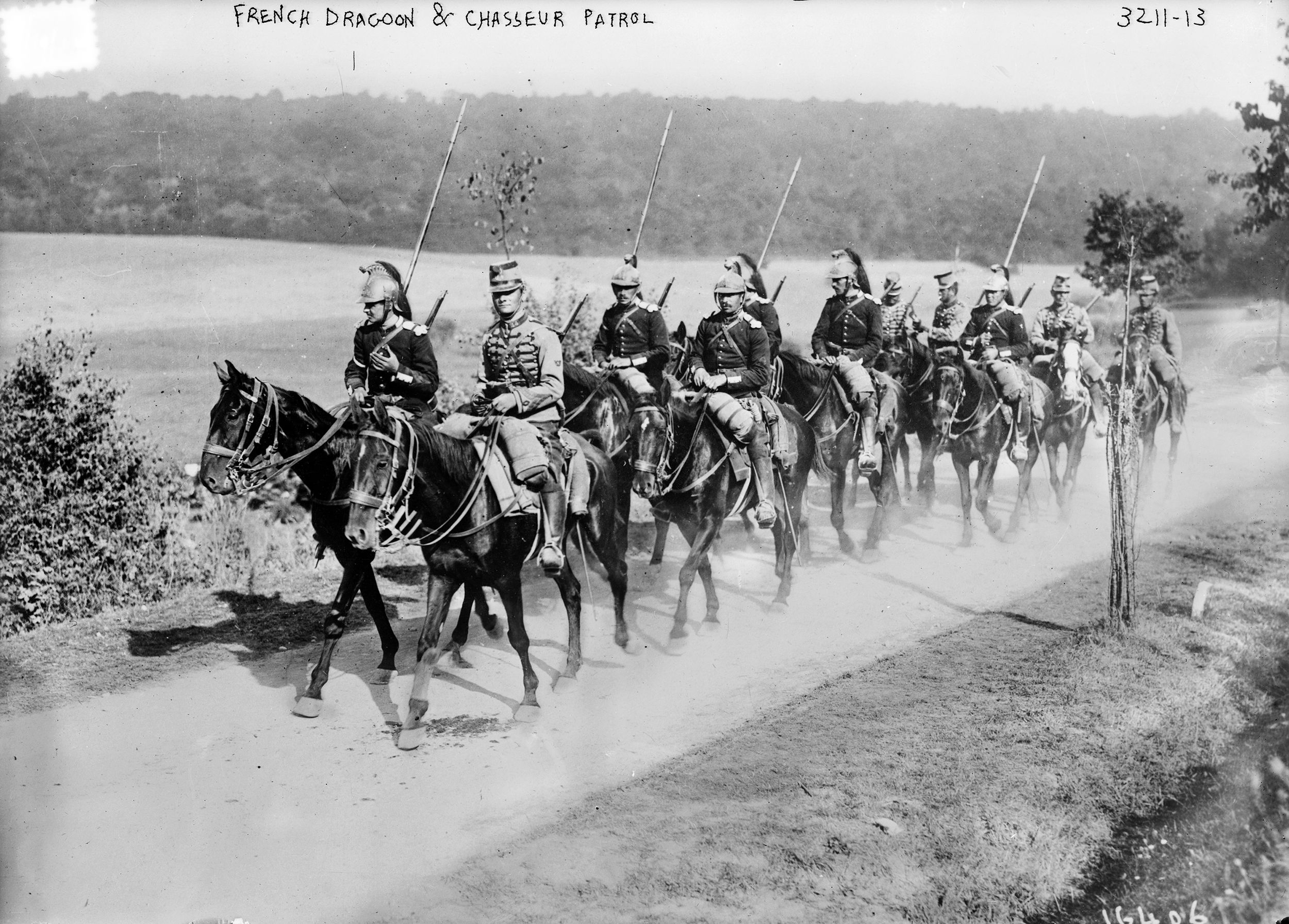 French dragoons and chasseurs in Napoleonic-style uniforms carry lances on patrol in 1914.