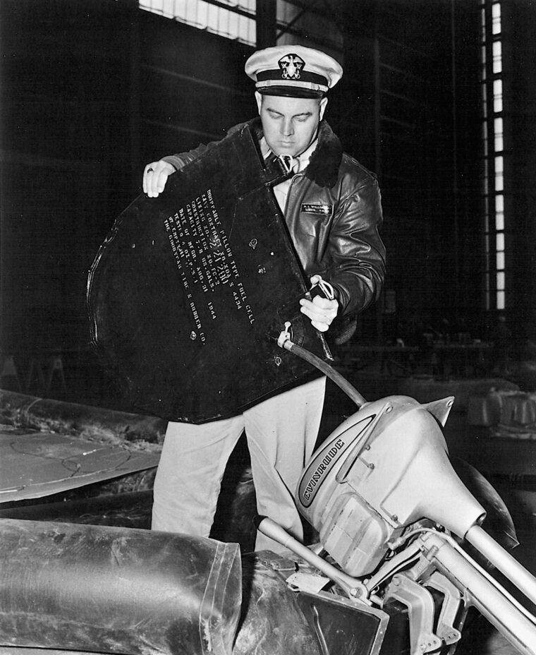 A Naval officer fuels an outboard motor with an air-droppable gasoline cell at the Lakehurst Naval Air Station in Lakehurst, N.J.