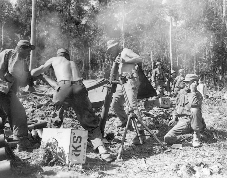 Shirtless crewmen fire 81mm mortar shells at well-defended Japanese positions on Hill 225. The strategically important hill sat adjacent to Maffin Airstrip on Wakde Island.