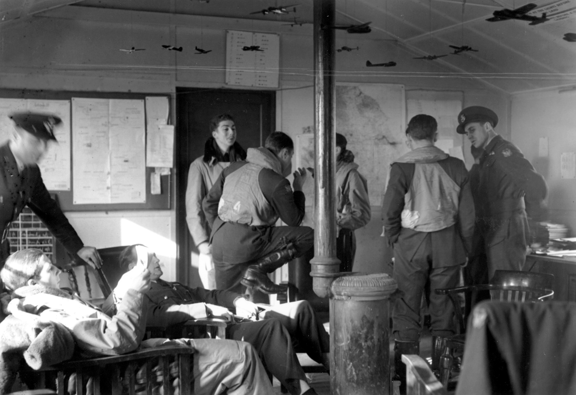 Eagle Squadron pilots engage in lively chatter and lounge around a dispersal hut as they await the word to take off on a training flight.
