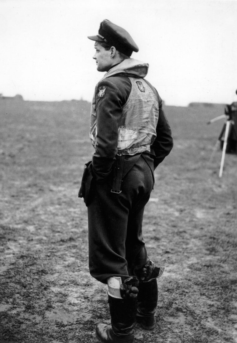 Pilot Officer Red Tobin, wearing his RAF uniform, stands at the edge of an English airfield. Tobin was one of many young American fliers who went to war for Britain prior to U.S. entry into the struggle against the Nazis.