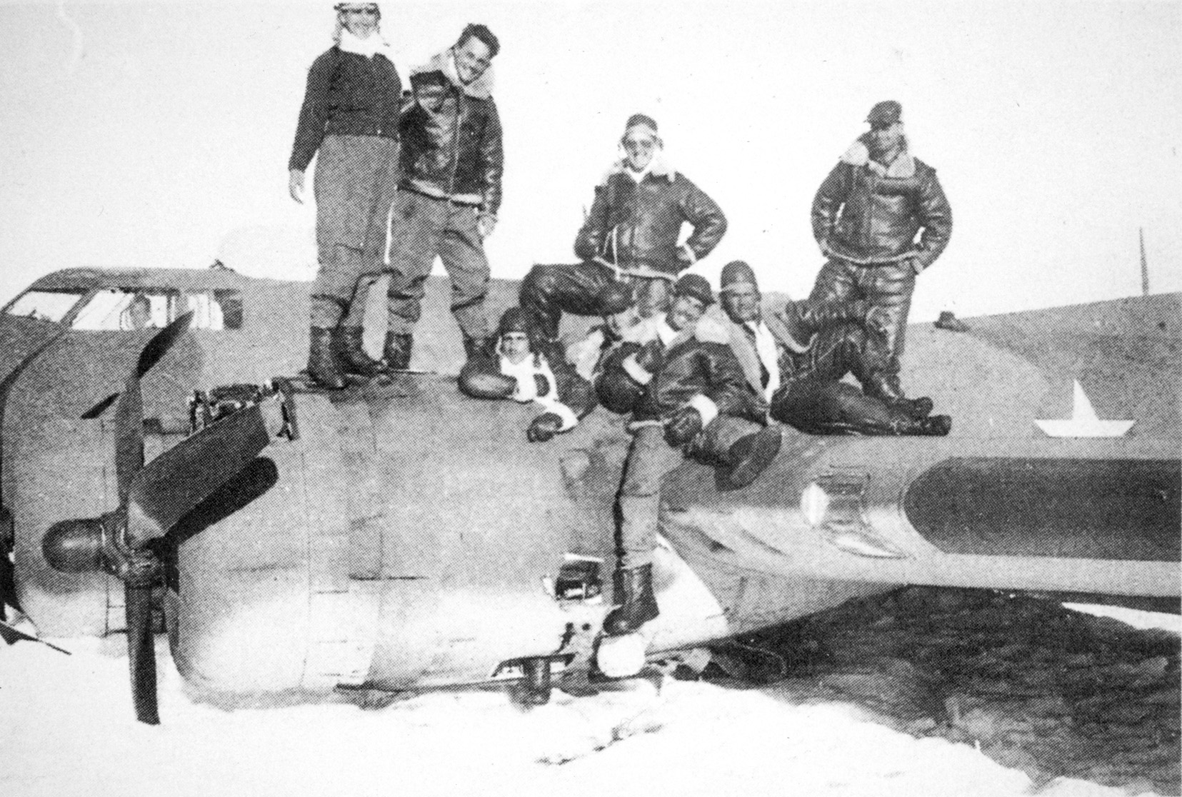 Shortly after their emergency landing on Greenland’s polar ice cap, crew members of a Boeing B-17 Flying Fortress bomber pose atop their damaged aircraft.