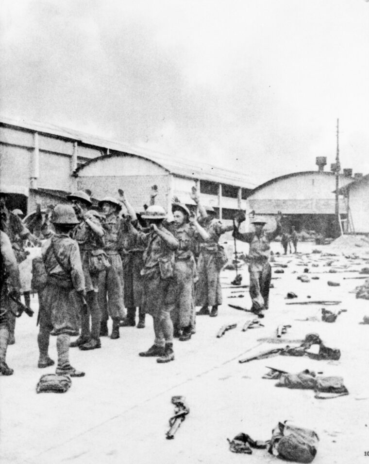 Their arms raised in surrender, British soldiers march toward years of captivity on February 2, 1942. The fall of Singapore was a disaster of the highest magnitude for the Allies.