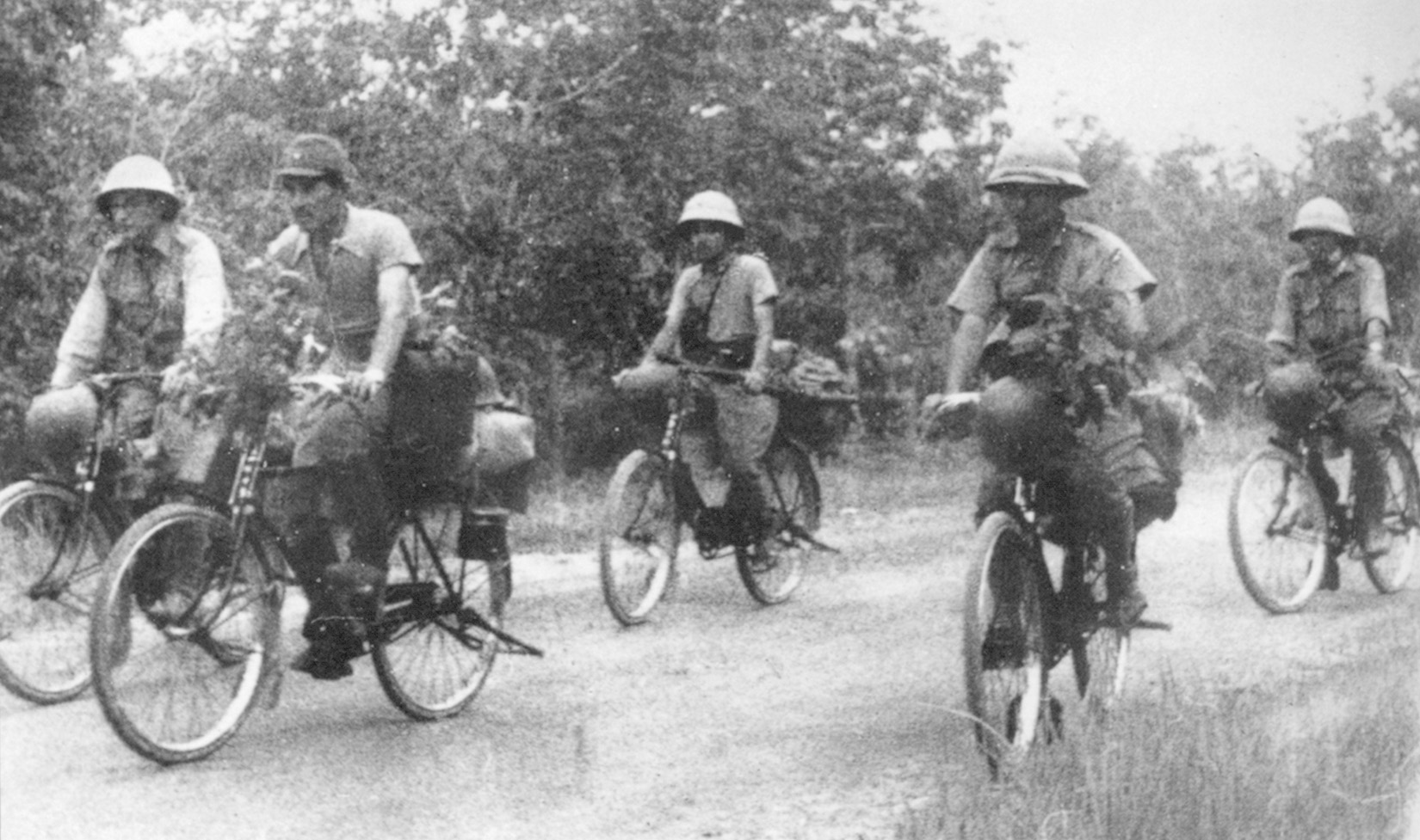 Riding bicycles, a Japanese unit rolls rapidly forward during the advance on Singapore. When the tires went flat, the soldiers continued to ride on the metal rims.
