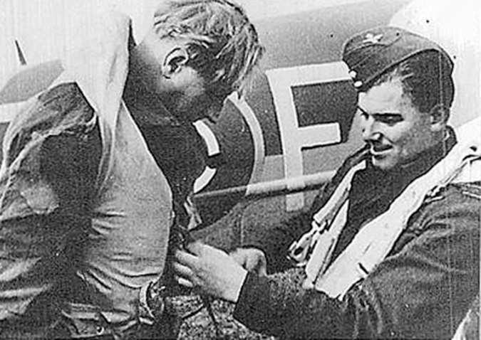 During a pre-takeoff equipment check, Flight Lt. J.A. Broadley makes an adjustment to the Mae West life jacket of Group Captain Percy C. Pickard. Both men were killed during the raid on Amiens prison.