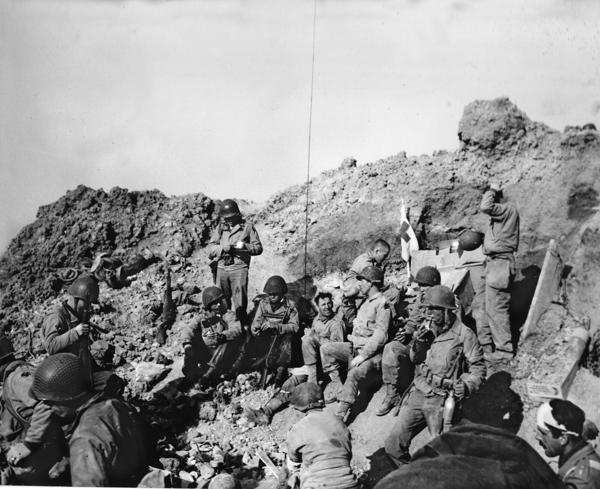 Tired and ragged, U.S. Army Rangers of the 2nd Battalion pause for a rest in a bomb crater. The Rangers captured the position at Pointe du Hoc, tracked down and destroyed the guns that had been removed by the Germans, and held their defensive perimeter until relieved by troops from the invasion beaches.