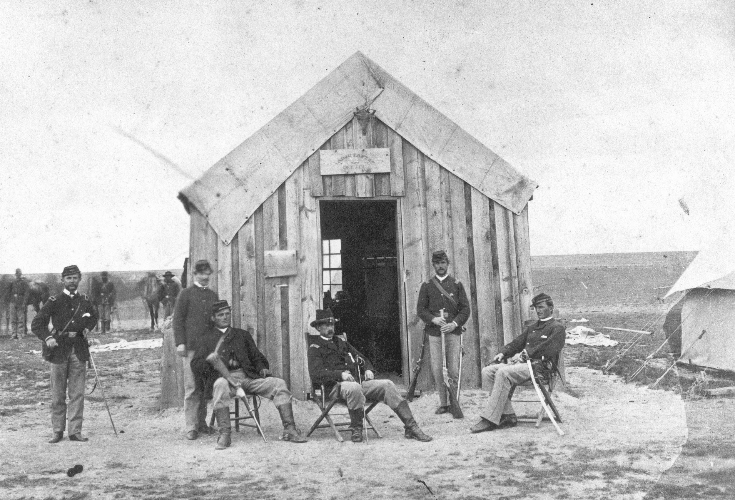 Taken only hours after the desperate fight against the collection of Plains Indians, this photograph by Dr. William A. Bell shows the Fort Wallace adjutant’s office, Captain Barnitz (center), Lieutenant Frederick Beecher (standing right), and other troopers in their fighting gear. 