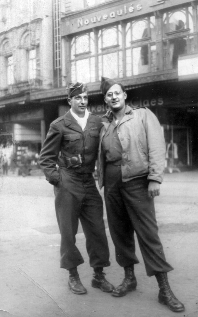 PFC Frank Cohn and another soldier pose for a photo in a Belgian town at the end of the war. Cohn spent his time after the war shipping German war criminal prosecution documents to the United States. 