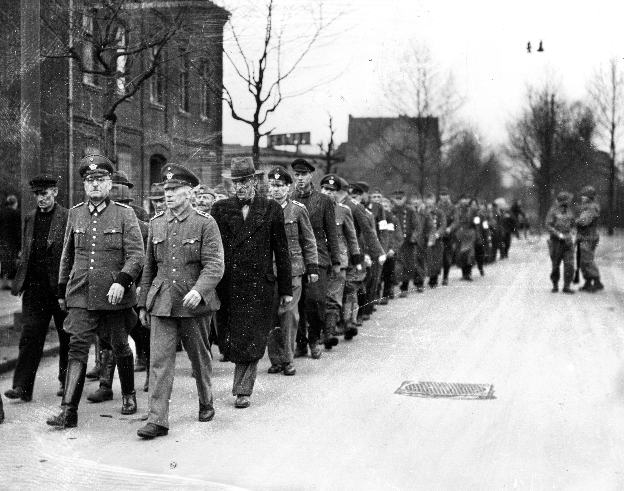 German prisoners, in various uniforms and civilian dress, march into captivity. Cohn found himself in charge of a group of surrendering Volksturm that an American POW camp did not want. 