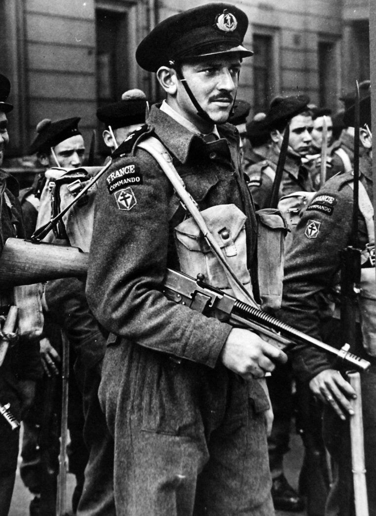 A French commando carries a Thompson submachine gun during the Bastille Day celebrations in 1943. The following year, after joining No. 4 Commando in preparation for D-Day, the French adopted British Army rank designations, along with the green berets. 