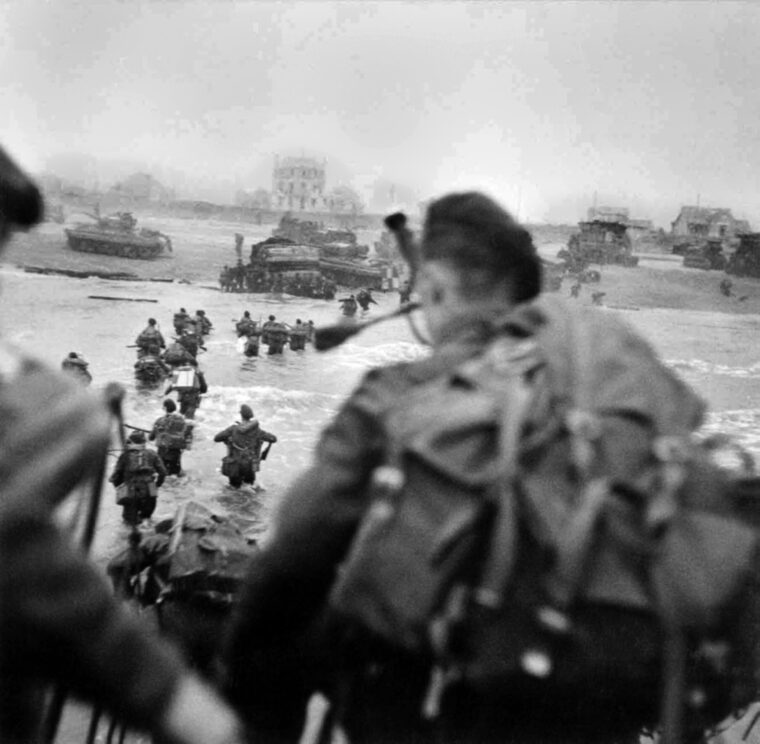Lord Lovat, visible in the water to the right of the column, wades ashore with his command at Sword Beach on D-Day. The commandos came ashore seven minutes after the first British troops hit the beach. 