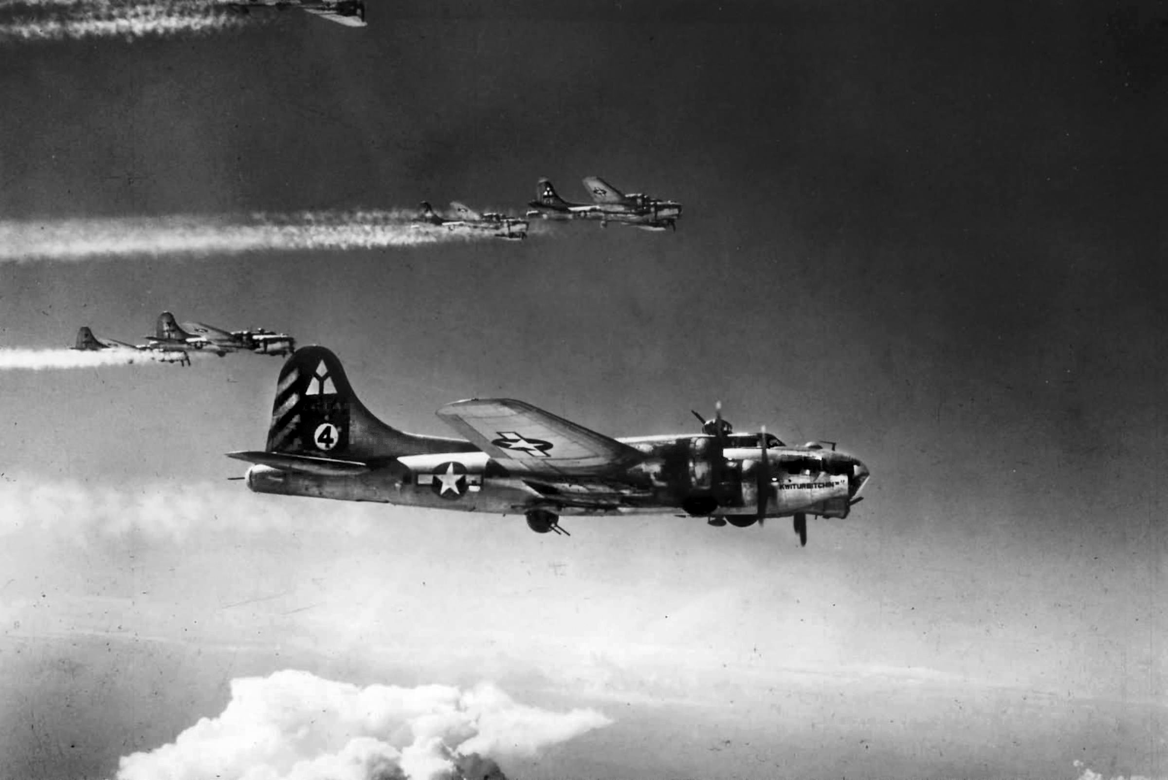Based at Foggia, Italy, in 1944, B-17 44-6544 “Kwitchurbitchin II” flies in formation with other B-17s of the 97th Bomb Group on a bombing run.