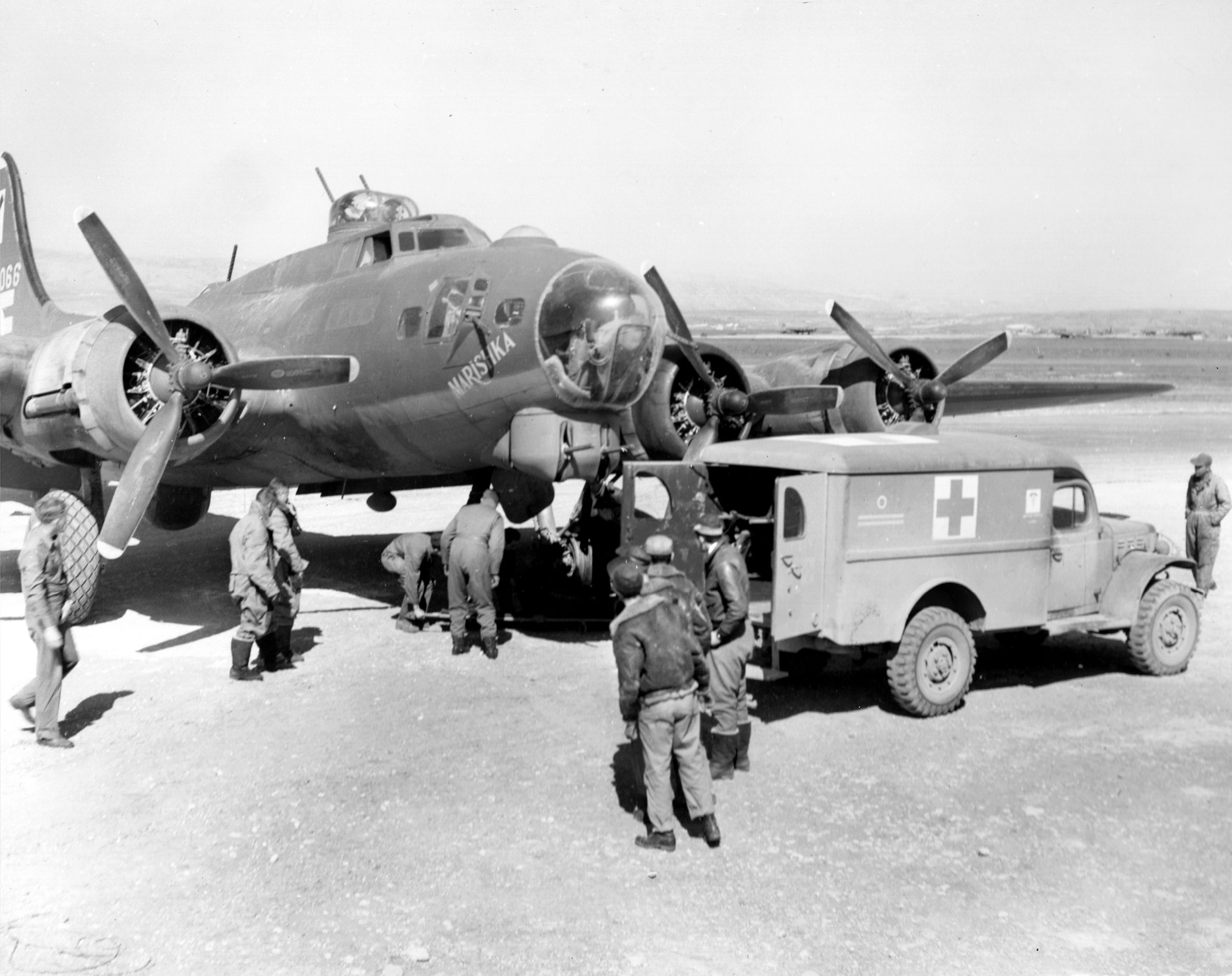At Amendola Field a stretcher crew (under fuselage) works to remove a casualty from a 97th Bomb Group B-17 “Marishka” after it returned from a combat mission. Tucker noted that after each mission a medic offered crews a shot of whiskey to help them through post-raid debriefings.