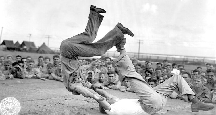 An instructor flips a soldier backward in hand-to-hand judo training. Infantrymen also learned how to incapacitate a man using a stick.