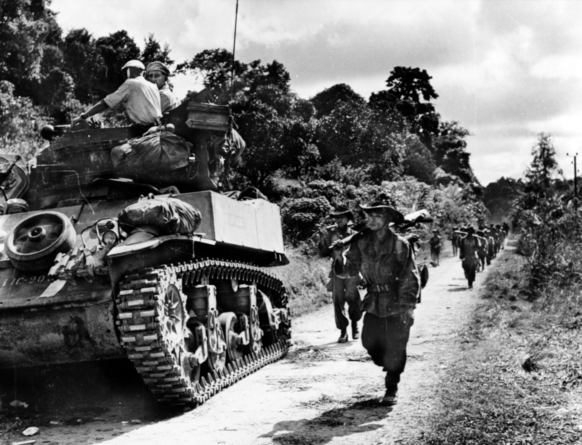 Infantry and armor move along Highway 2 across the forested country of North Vietnam toward Phu Doan, a suspected Viet Minh weapons depot.
