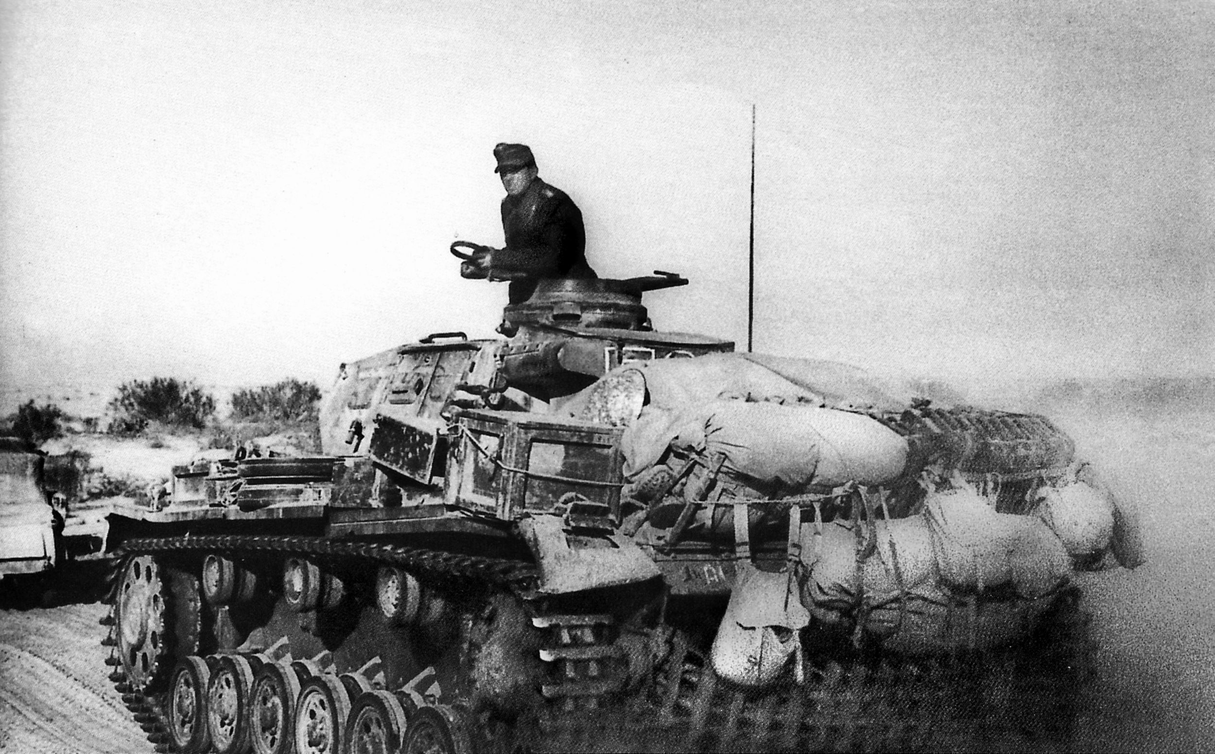 An Afrika Korp panzer, loaded with gear, travels over a desert track during the advance on Tobruk in March, 1941. The besieged Allied forces in Tobruk, supplied by sea, would hold out for 242 days until New Zealand troops of the British Eighth Army broke through on December 7, 1941. Rommel would finally take Tobruk on June 20, 1942.