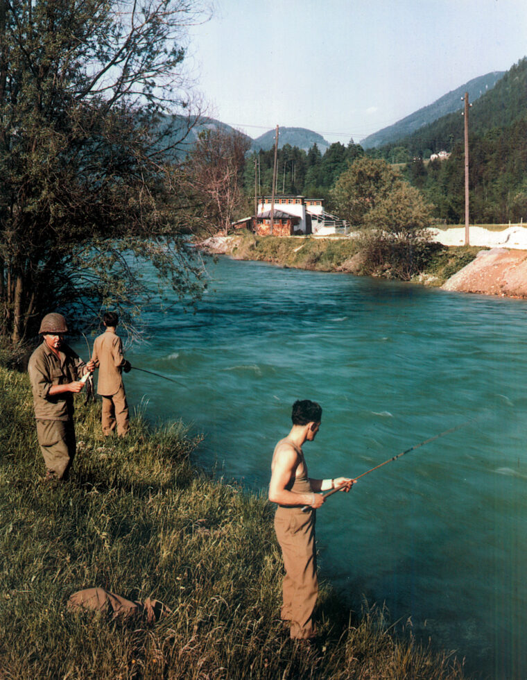 Those fishermen in baggy pants: shedding combat gear for fishing poles, glidermen pass the time by fishing in the King River. Despite the relaxation, the men continued to train for war, believing they were headed to the Pacific for the invasion of Japan.