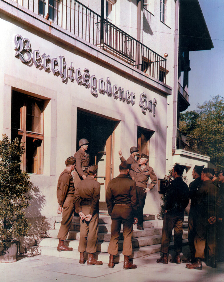 Soldiers as tourists: a band of Screaming Eagles listens to Lieutenant Louis Merz as he explains the Berchtesgaden Hof, a local inn. Berchtesgaden was a resort village, but the war deprived all the stores of their wares. The only major occupation of the townspeople by the end of the war was inn keeping. Almost every building in the town bore a sign identifying it as a hotel, inn, or Gastof.