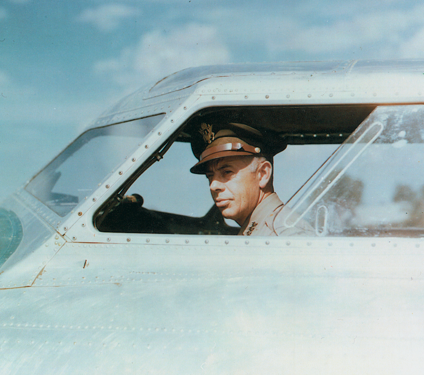 General George C. Kenney peers from the cockpit of a Boeing B-17 bomber.