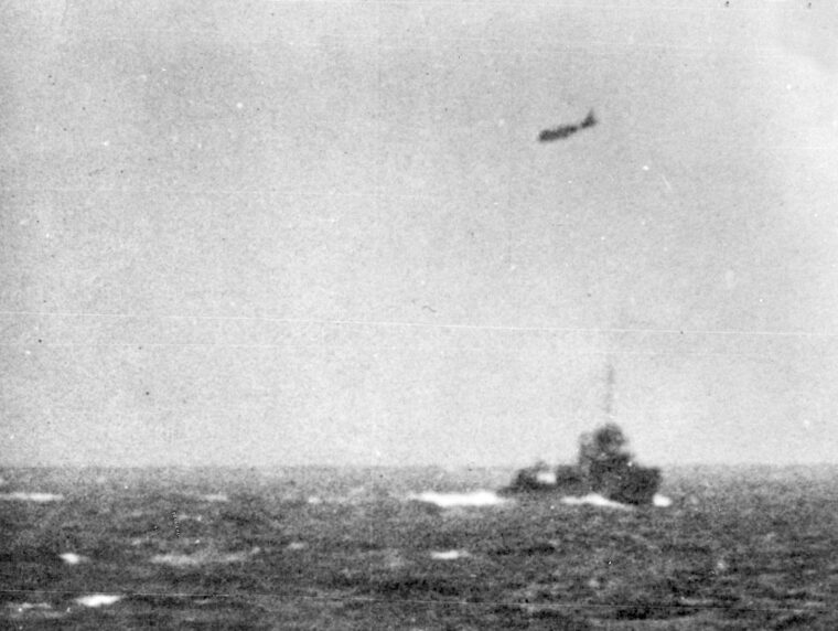 A Japanese torpedo bomber flies past a U.S. destroyer en route to attack the aircraft carrier Lexington. 