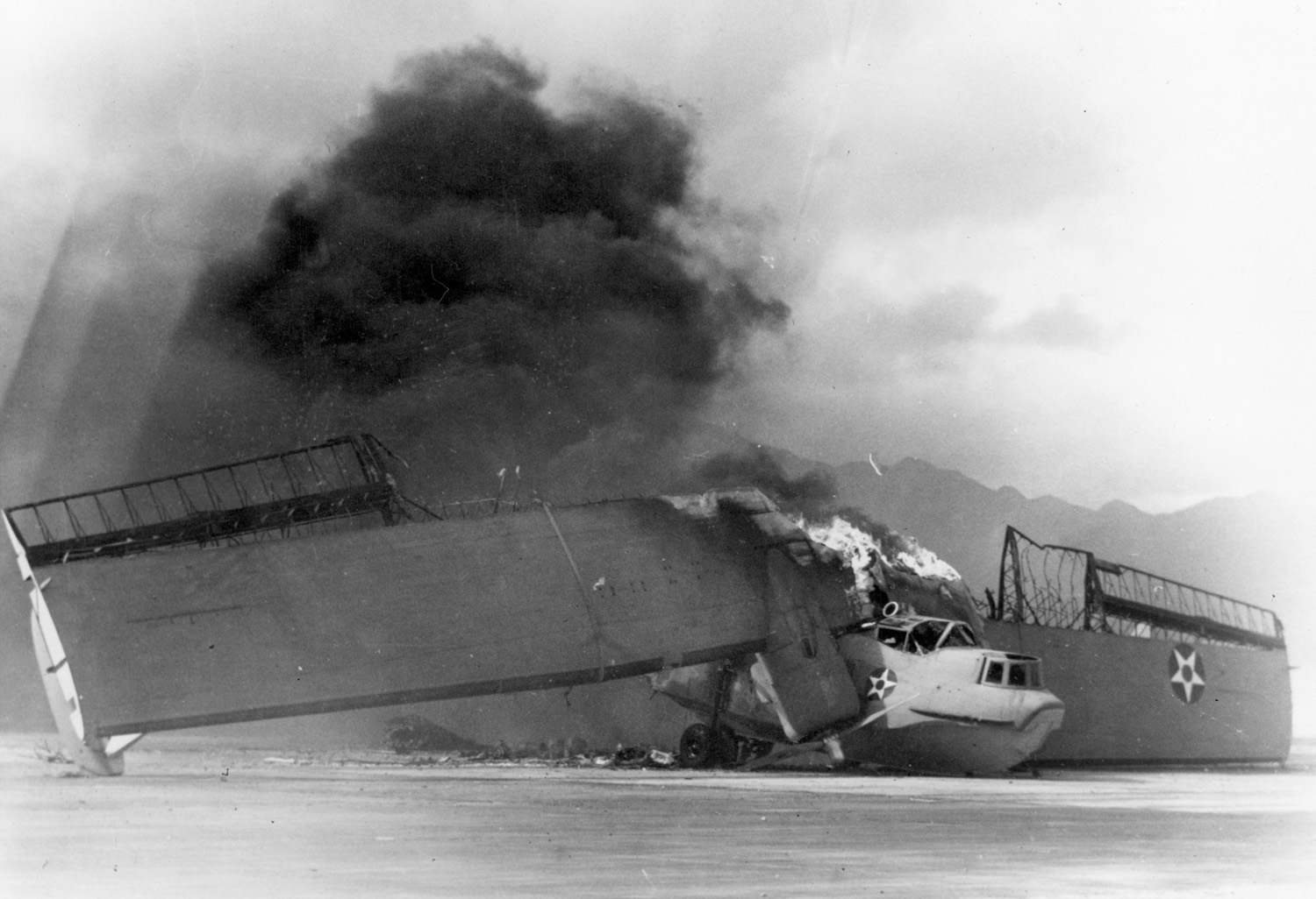In a photo believed previously unpublished, a Consolidated PBY Catalina flying boat burns fiercely following the Japanese attack on Pearl Harbor.