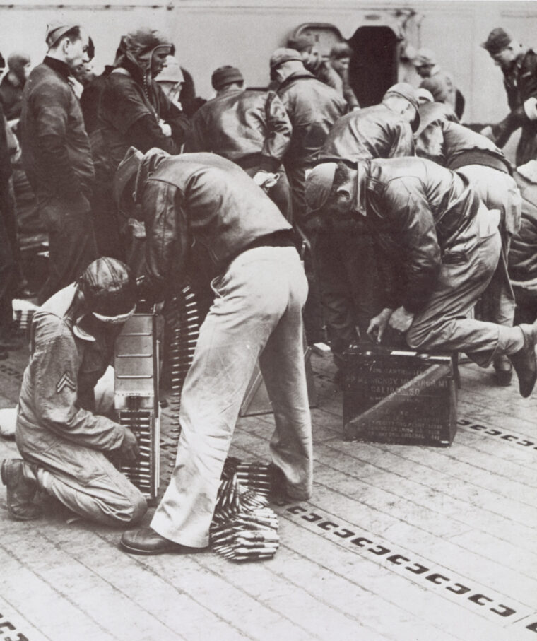Preparing for their mission, a bomber crew loads .50-caliber machine-gun ammunition aboard the carrier Hornet.