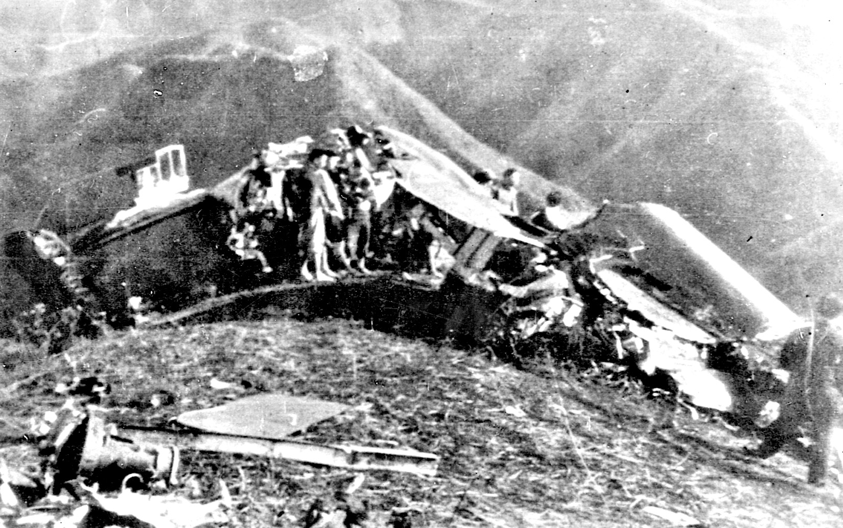 The wreckage of Doolittle’s shattered plane is strewn across a hillside in China. Doolittle is seated on the wing near the plane’s insignia.