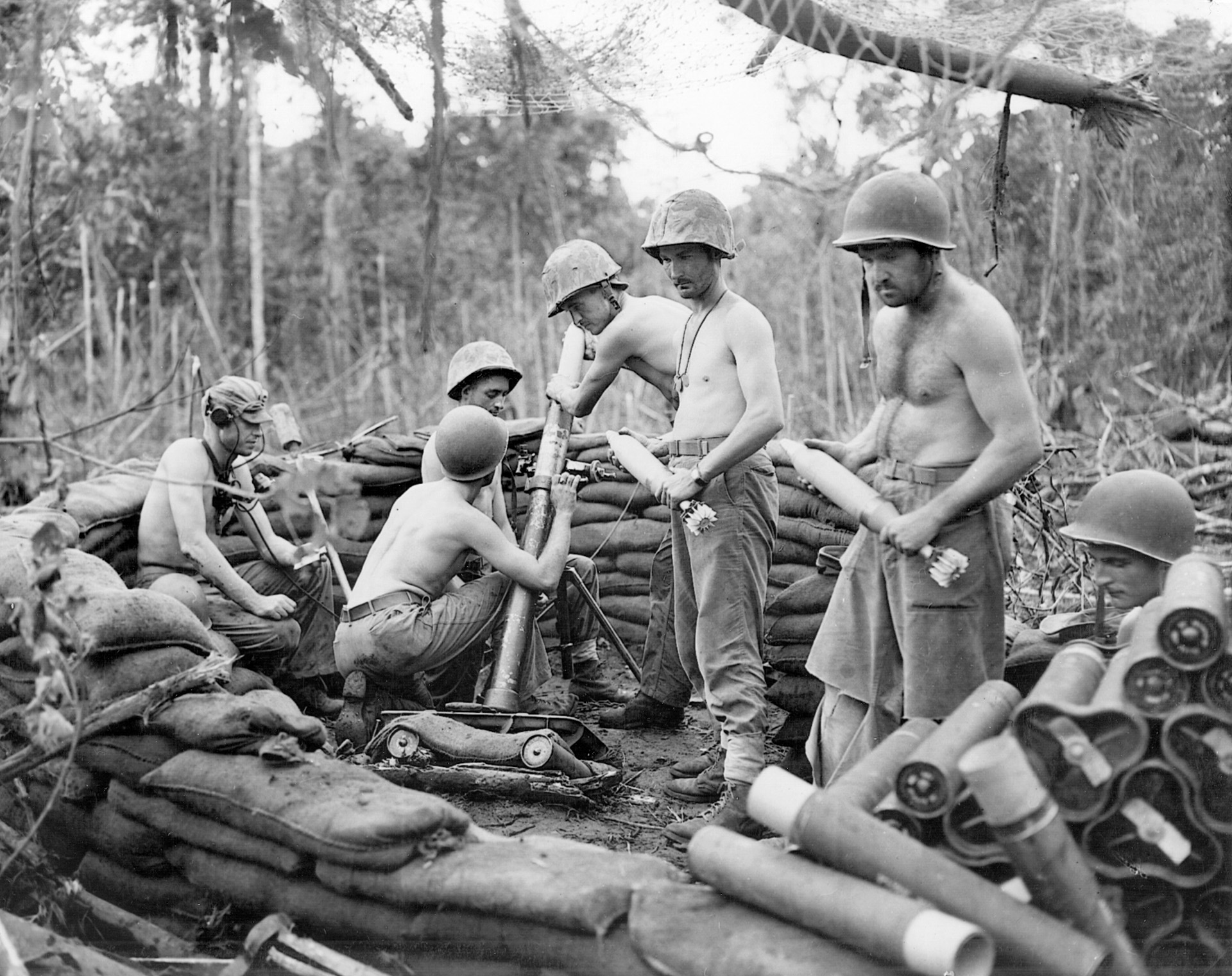 Their 81mm mortar in action, Marines pass shells forward during operations on New Guinea in the spring of 1944.