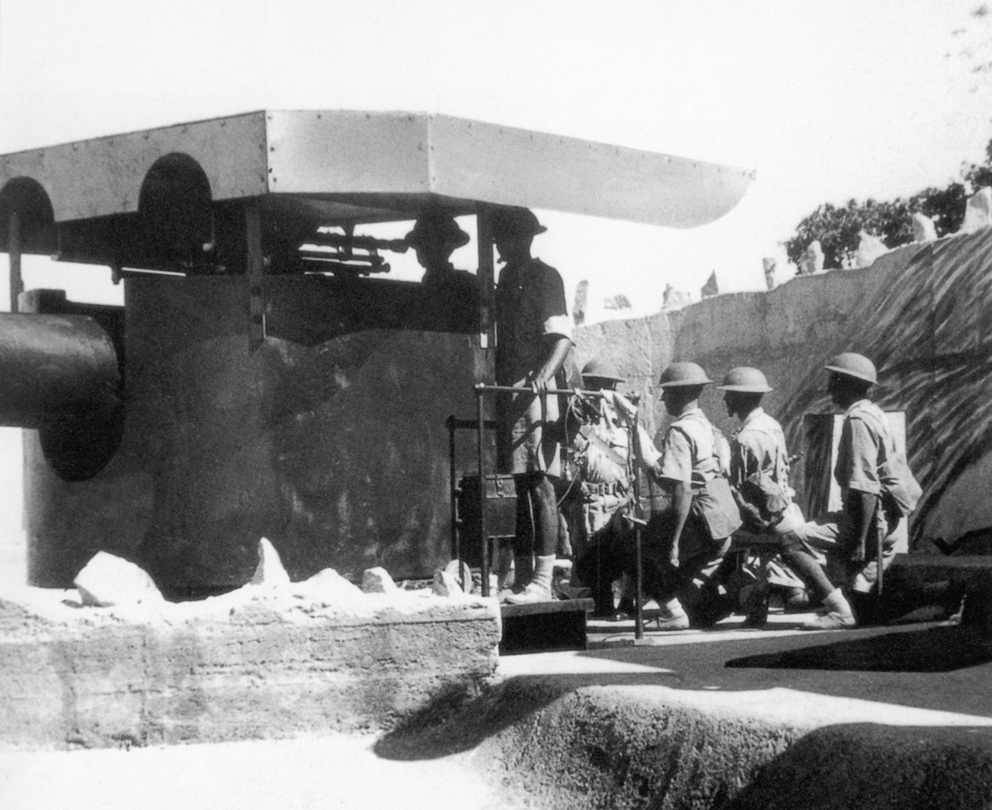 Indian soldiers man a coastal defense gun at Hong Kong. The city was well equipped for an attack by water, but did not have the resources to defend against a land invasion.