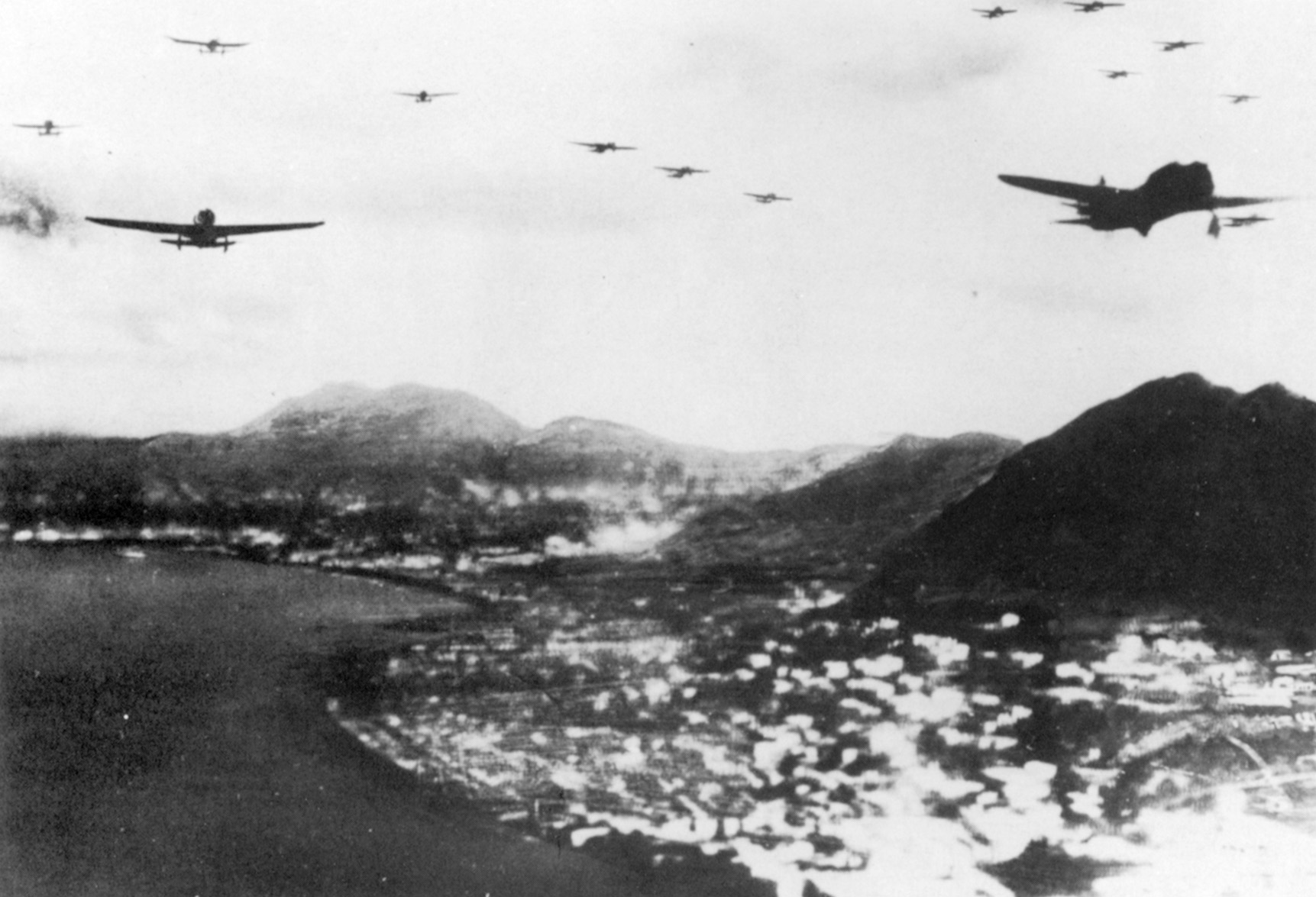 A formation of Japanese planes flies over Causeway Bay and heavily populated areas along Hong Kong’s northern shore. Mount Parker can be seen in the background.