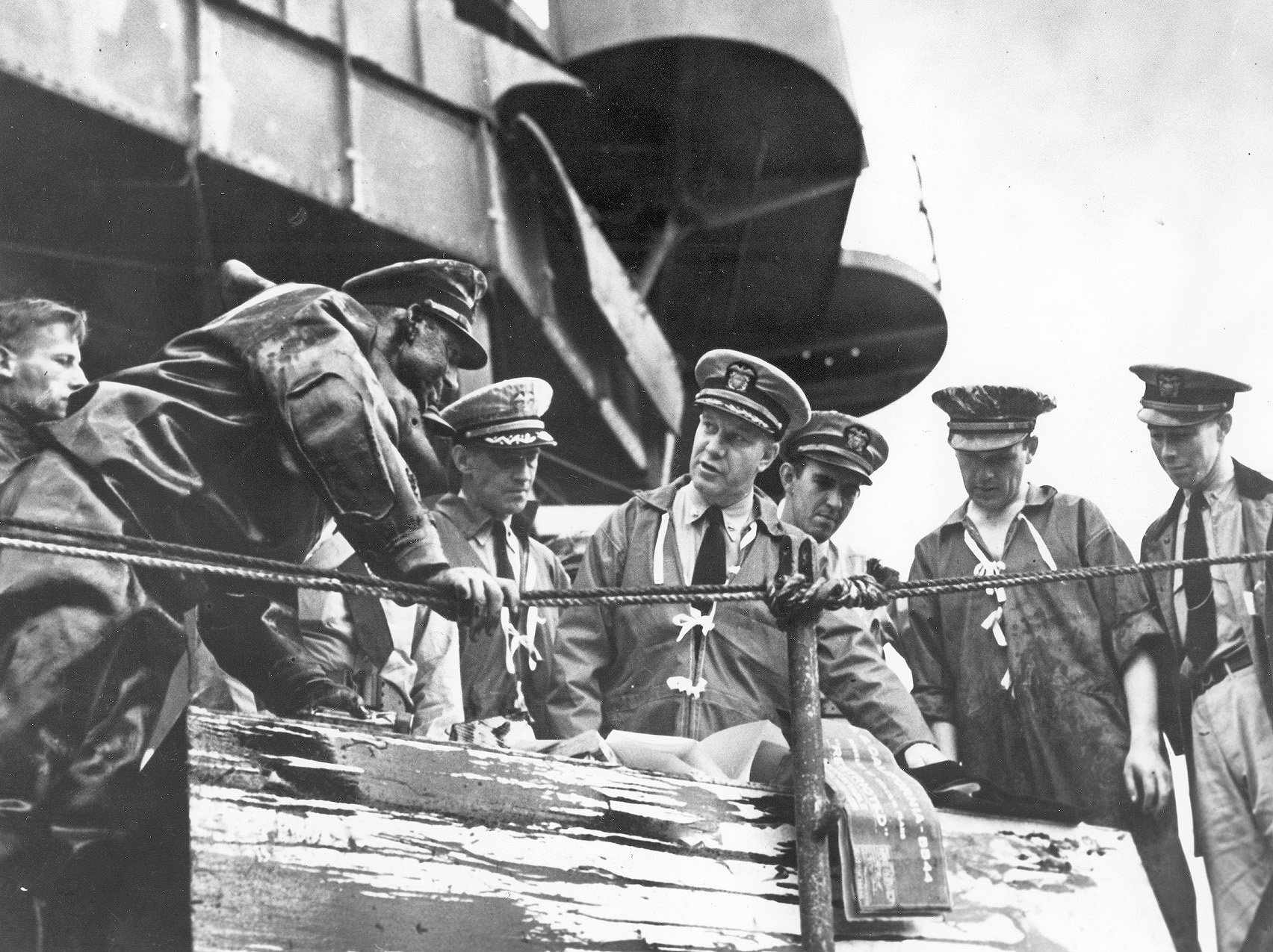 Members of the salvage team assigned to the battleship California discuss their next move. Captain Homer N. Wallin is fourth from the left.