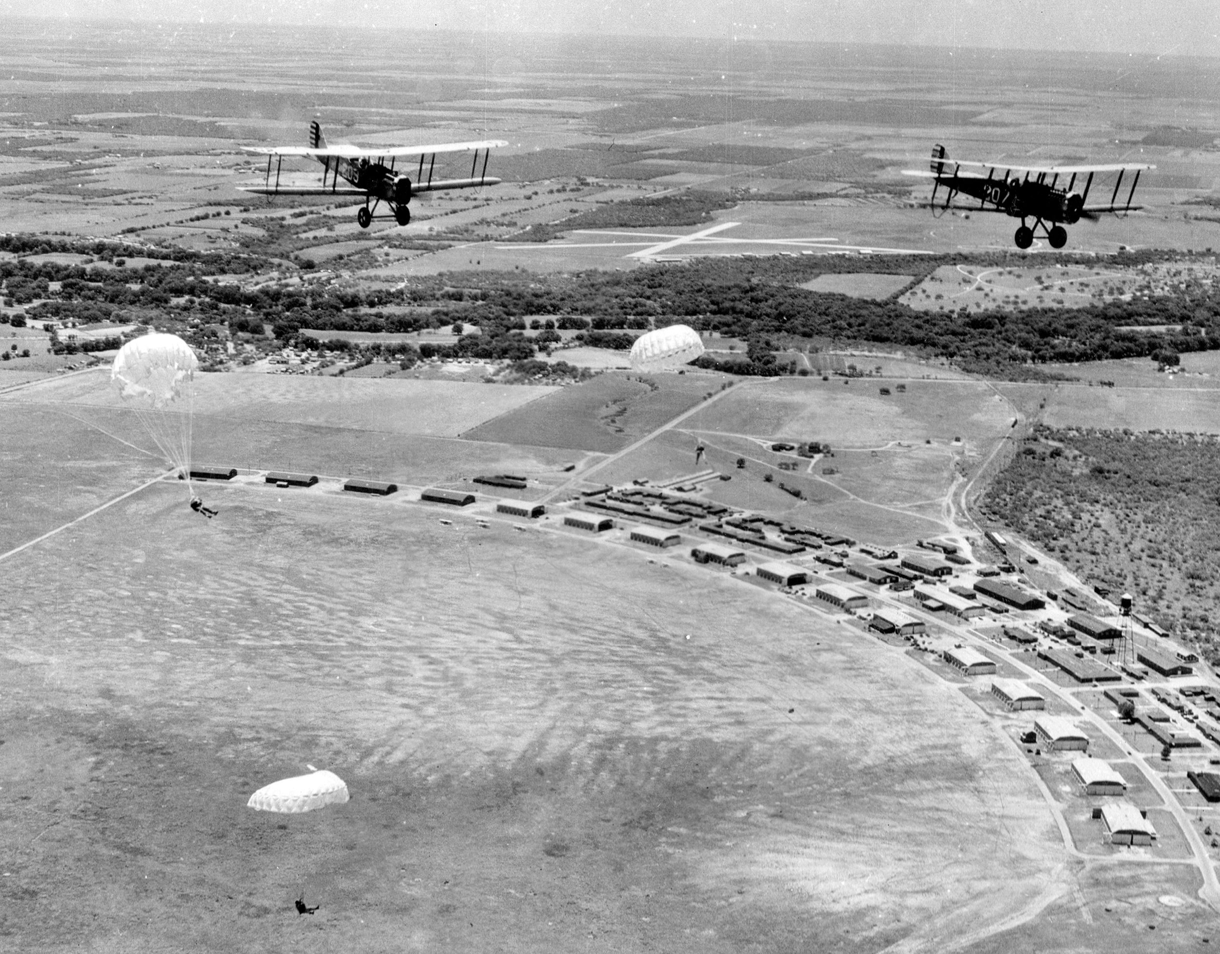 Army paratroopers jump from biplanes during an early airborne exercise at Brooks Field, Texas, in the mid-1920s. The military showed little interest in Airborne capability until the late 1930s.