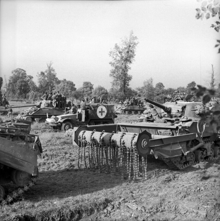 During the opening hours of Operation Goodwood, a Sherman tank carrying infantrymen, a Sherman flail tank nicknamed a “Crab,” and a halftrack serving as an ambulance await orders to advance on July 18, 1944. Caen was a D-Day objective, but the Allies were required to fight for weeks to capture the town.