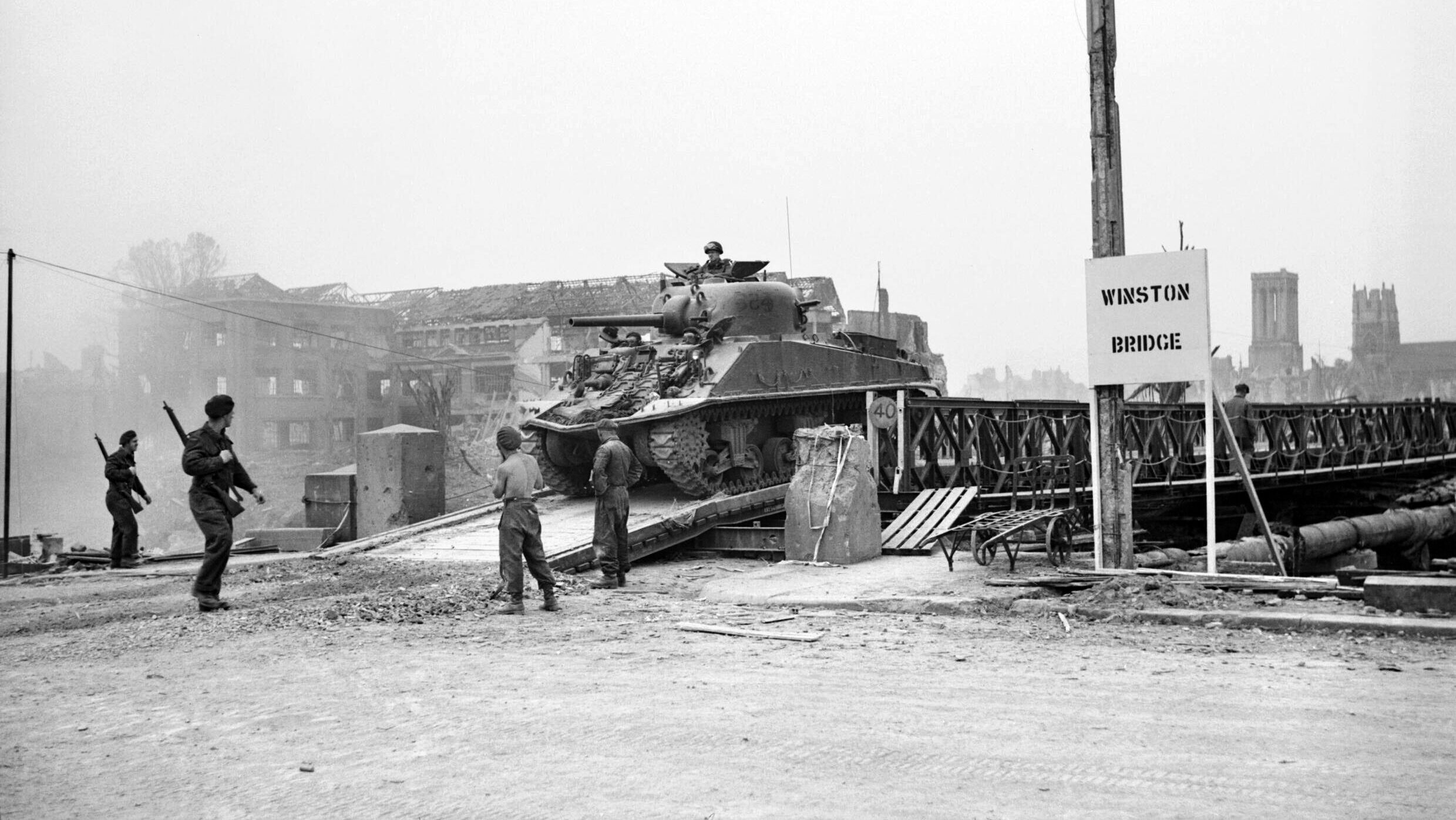 A Sherman tank successfully crosses Winston Bridge, a British Bailey bridge erected across the Orne River in preparation for the Operation Goodwood offensive. After weeks of fighting, Caen was finally secured, and both the Allies and the Germans had paid a high price.