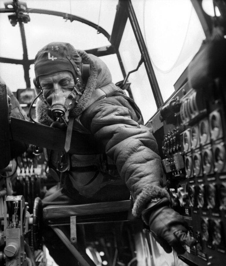 During preparations for the approach to a target inside Germany, a flight engineer aboard an Avro Lancaster heavy bomber of No. 619 Squadron RAF checks engine settings. Note he has already donned his oxygen mask, necessary for flight at high altitude.