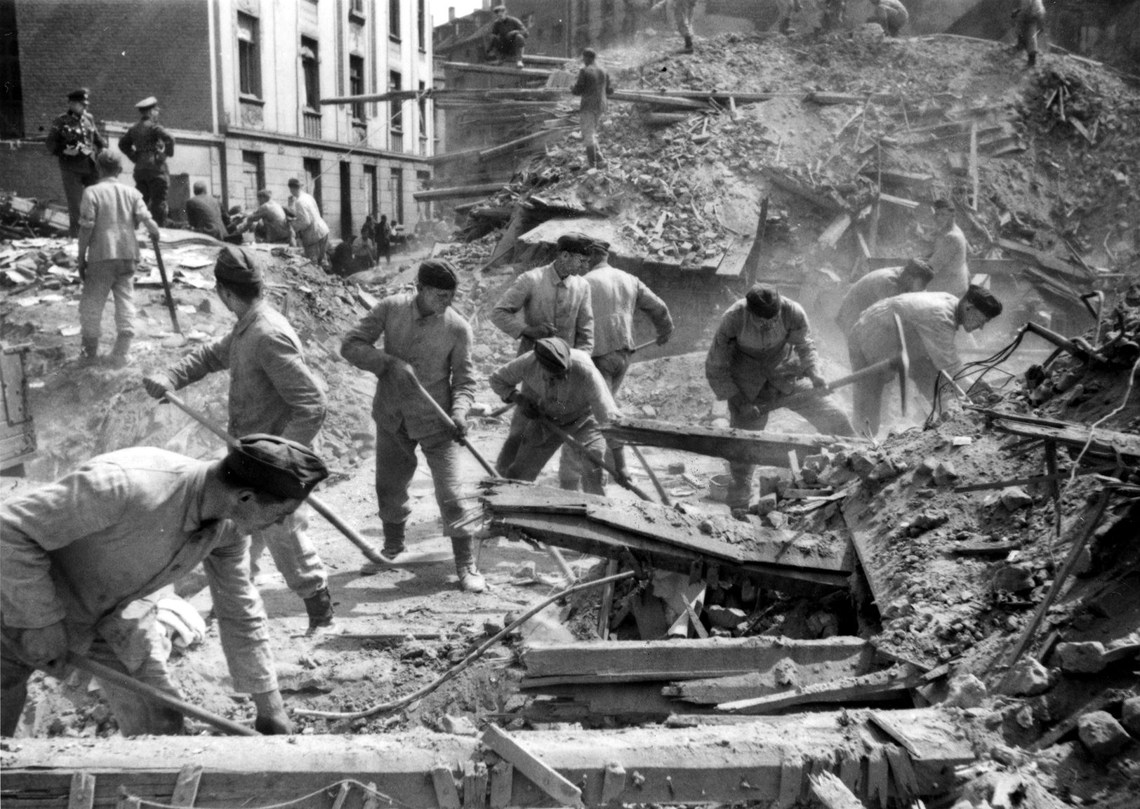 Military personnel detailed to clear rubble from the streets of Cologne labor to complete the task after one of many Allied air raids against the city during World War II. A total of 898 RAF bombers actually reached Cologne during the 1,000-plane raid, but despite widespread destruction the productivity of area factories was slowed only for a month.